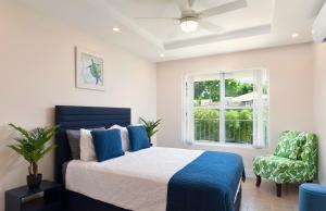 a bedroom with a bed and a window and a chair at Modern 2BR Beachside Haven Ground Floor and Pool in Saint Peter +28 photos