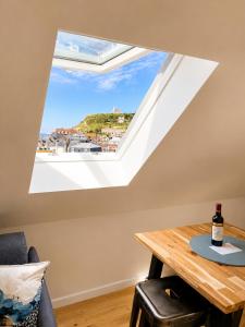 a window in a room with a table with a bottle of wine at Le bleu infini - vue mer, falaises, centre ville in Étretat