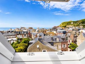 a view of a city from the roof of a building at Le bleu infini - vue mer, falaises, centre ville in Étretat +9 photos