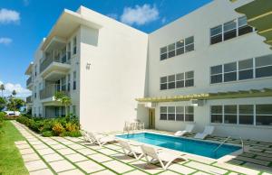 an exterior view of a building with a swimming pool at Modern 2BR Beachside Haven Ground Floor and Pool in Saint Peter
