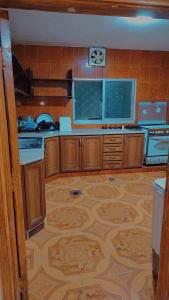 a kitchen with wooden cabinets and a wooden floor at Lovely hotel in Al Qābūţī