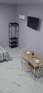 a dining room with a table and chairs and a tv at Apartment Torres in Manuel Antonio