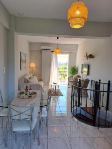 a dining room and living room with a table and chairs at Το Είδωλον Sea Maisonettes & Studio in Ancient Epidauros