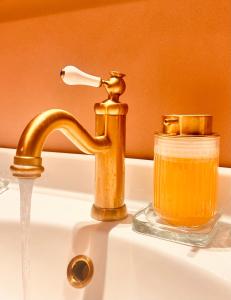a sink with a gold faucet and a jar of honey at Le Palm House has two bedrooms with the breathtaking view over lake Como in Perledo