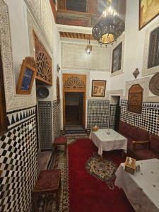 a room with two tables and a chandelier at Riad dar Kirami in Fez