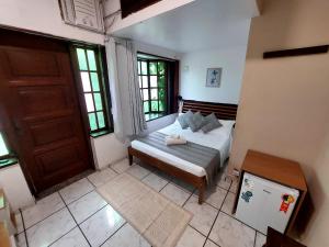 a small bedroom with a bed and a door at Pousada Casa da Pedra in Búzios +20 photos