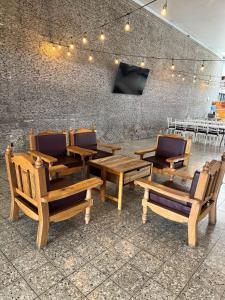 a group of wooden tables and chairs in a room at HOTEL FLAMINGOS DE CIUDAD GUZMAN in Ciudad Guzmán