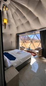 a bedroom with a bed and a large window at Olivia Rum Luxury Bubbles & Jeep Tours in Wadi Rum +137 photos