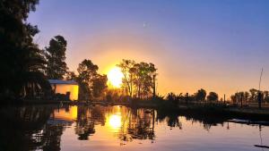 a sunset over a river with the sun setting at La Elegida Villars in General Las Heras