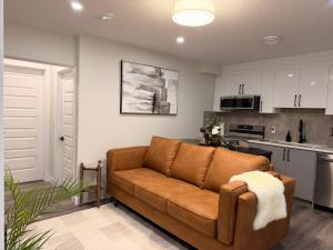 a living room with a brown couch in a kitchen at Eden Secret YYC in Calgary +32 photos