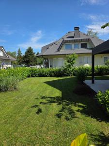 a house with a large yard with a grass field at Private House with Jacuzzi and Sauna in Domžale