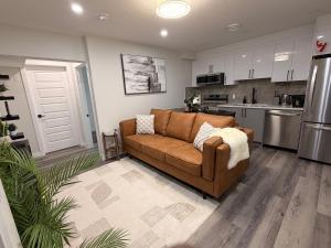a living room with a brown couch in a kitchen at Eden Secret YYC in Calgary