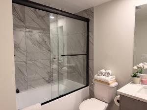 a bathroom with a glass shower with a toilet at Eden Secret YYC in Calgary