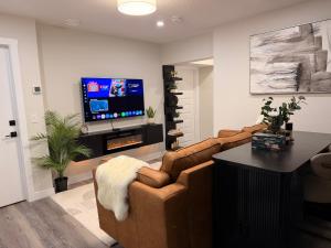 a living room with a couch and a tv at Eden Secret YYC in Calgary