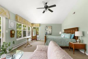 a bedroom with a bed and a ceiling fan at Waterfront Estate w Hot Tub, Dock & Kayaks in Stonington +63 photos