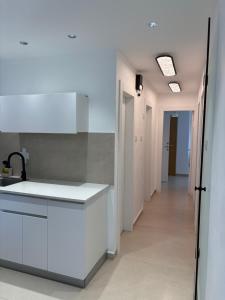 a kitchen with a white counter and a hallway at Mykonos unite in Rishon LeẔiyyon