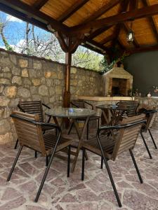 a patio with a table and chairs and a stone wall at Adzija House in Ohrid