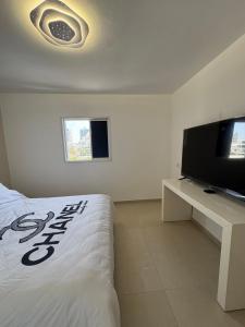 a bedroom with a bed and a flat screen tv at Mykonos unite in Rishon LeẔiyyon