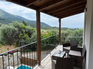 a balcony with chairs and a table and a pool at Abigails Pool House in Kallirákhi