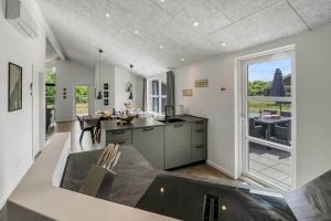a kitchen with a large window and a table at C11349-Tarm-Stikkelsbaervej-43 in Tarm