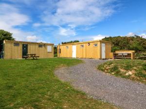 zwei Gebäude mit einem Picknicktisch im Gras in der Unterkunft Cwt Bugail in Pwllheli + 26 Fotos