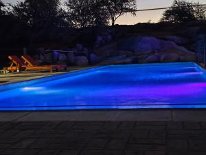 a swimming pool lit up in blue at night at Atardecer serrano in Mina Clavero