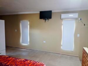 a bedroom with a bed and a tv on the wall at Atardecer serrano in Mina Clavero