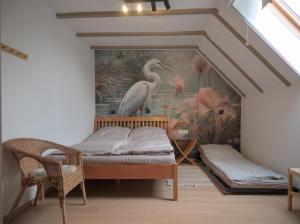a room with a bed and a painting of a bird at Vadvirág Villa in Soltvadkert
