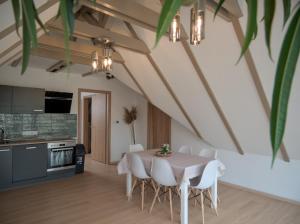 a kitchen and dining room with a table and chairs at Vadvirág Villa in Soltvadkert