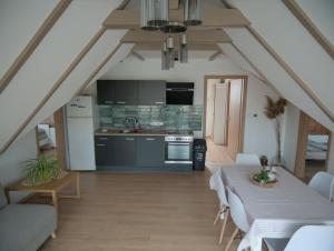 a kitchen and living room with a table and chairs at Vadvirág Villa in Soltvadkert +20 photos