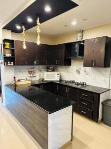 a kitchen with brown cabinets and a black counter top at Apartment In Ayubia in Naka