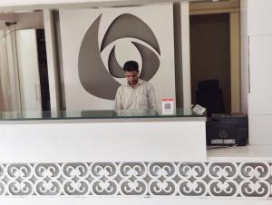 a man standing behind a counter in an office at Hotel Mumbai House Thane in Thane