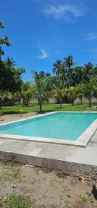 an empty swimming pool in a park with palm trees at Honey Beach House in La Esmeralda