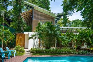 a house with a swimming pool in front of a house at Porto Alegre Villas in Punta Uva