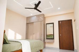 a bedroom with a bed and a ceiling fan at The jaish heaven in Rushikonda