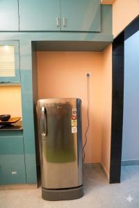 a stainless steel refrigerator in a kitchen with cabinets at The jaish heaven in Rushikonda