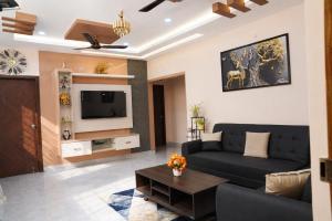 a living room with a couch and a tv at The jaish heaven in Rushikonda