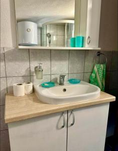 a bathroom counter with a sink and a mirror at Two Olives Vacation Homes in Slatina Varoš