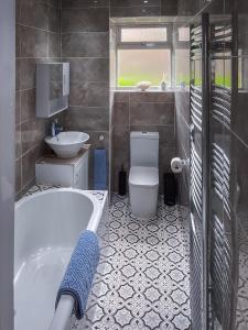 a bathroom with a tub and a toilet and a sink at Vistamar Dunoon in Dunoon +37 photos