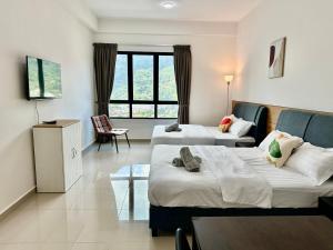 a hotel room with two beds and a window at Studio 4pax SunshineKekloksiView in Ayer Itam