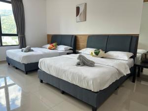 two beds with stuffed animals on them in a bedroom at Studio 4pax SunshineKekloksiView in Ayer Itam +9 photos
