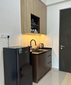 a kitchen with a black refrigerator and a sink at Studio 4pax SunshineKekloksiView in Ayer Itam