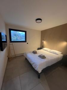 a bedroom with a bed with a tv on the wall at Les Loges de Sainte Anne in Saint-Michel-de-Maurienne