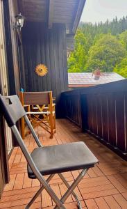 a chair sitting on a porch with a view of a porch at Jagdhof Apartments am Spitzingsee in Schliersee