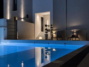 a house with a swimming pool at night at L'aTTIQUE in Kastanéa