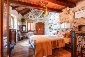a bedroom with a bed and a stone wall at House Morski brk in Trogir