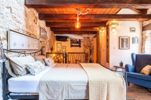 a bedroom with a large bed and a chair at House Morski brk in Trogir +7 photos