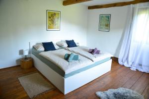 a bedroom with a white bed with blue and purple pillows at 1st Truffle House Žumberak 