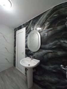 a bathroom with a sink and a mirror at Vila Familjare Memushi in Ksamil