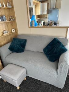 a gray couch with two blue pillows in a room at Duckpool 108 Bude in Bude